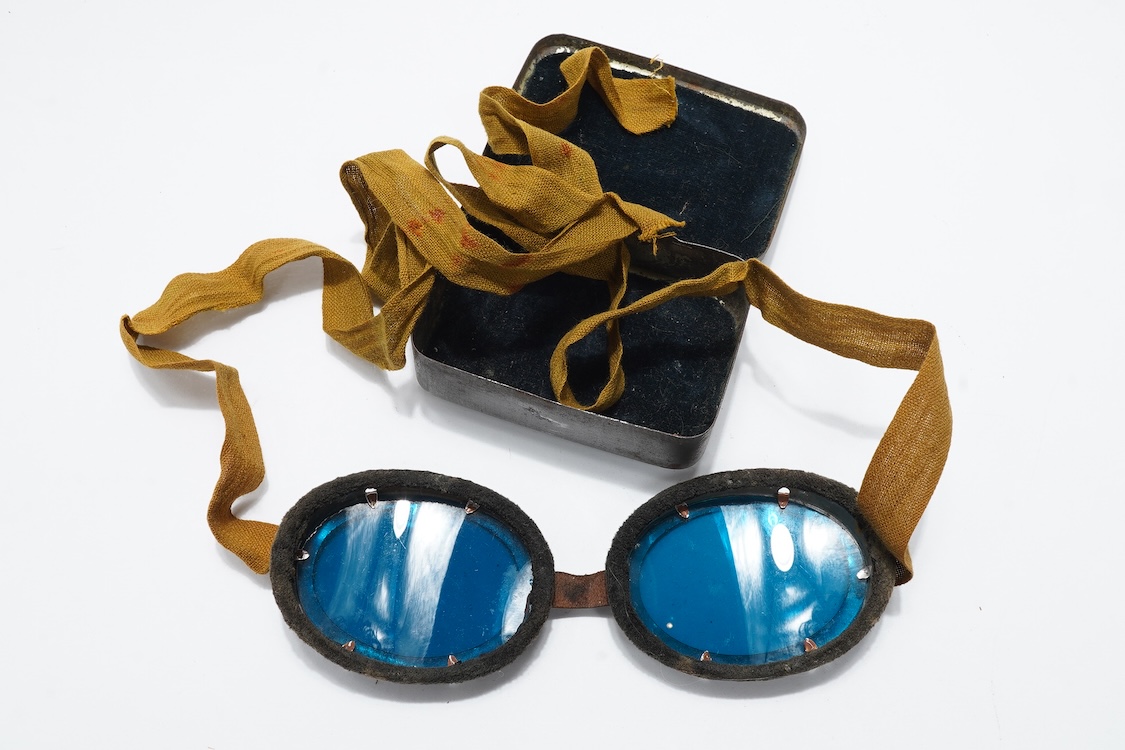Two pairs of WW2 desert goggles, blue tinted lenses, one with original tin box
